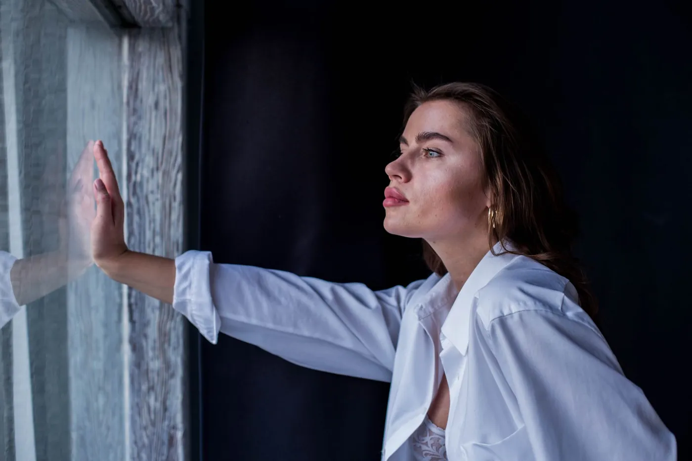 Mujer mirando por la ventana, en calma